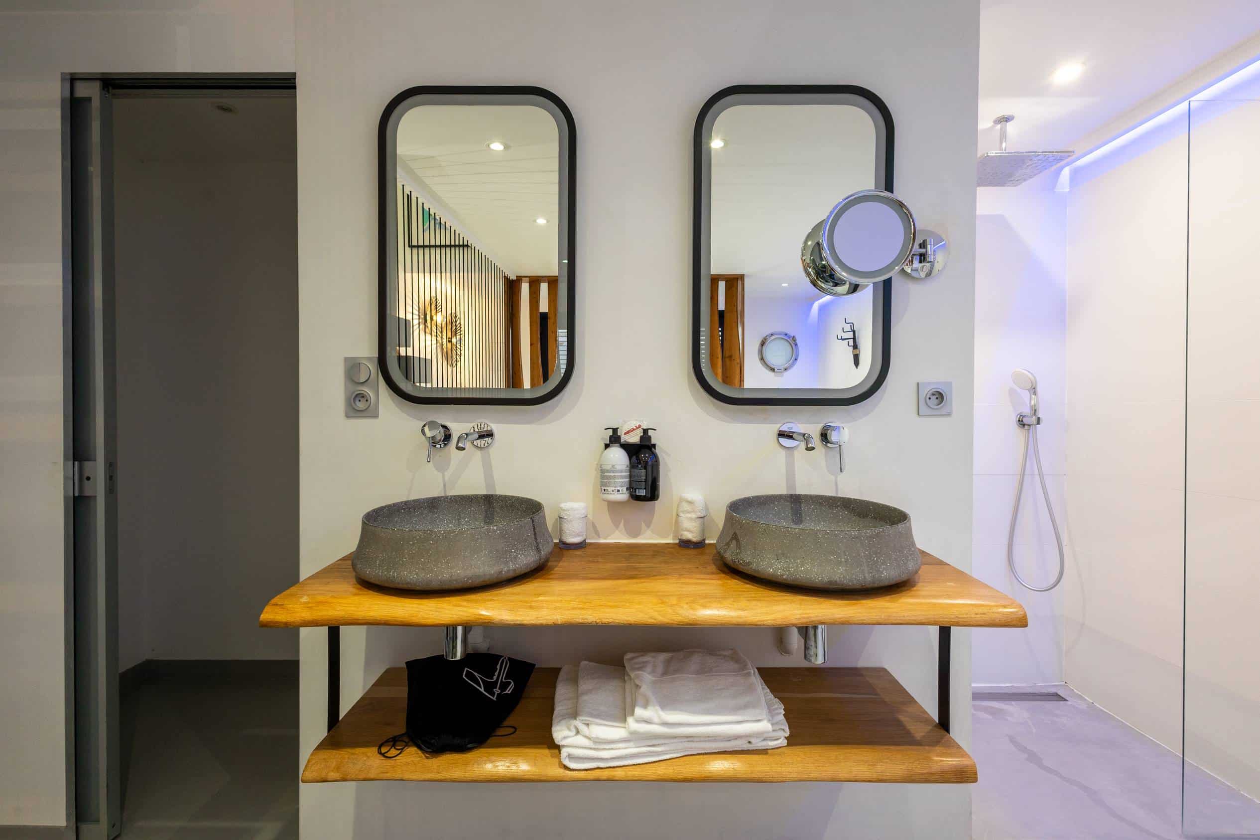 Salle de bain moderne avec double douche et jacuzzi dans la Suite Santorin